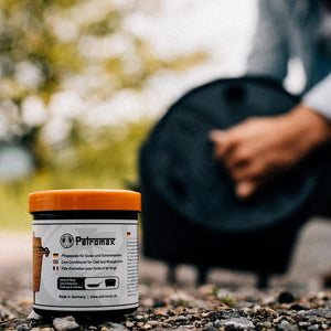 Moodbild: Die Petromax Einbrenn- & Pflegepaste, 250ml steht auf dem Boden