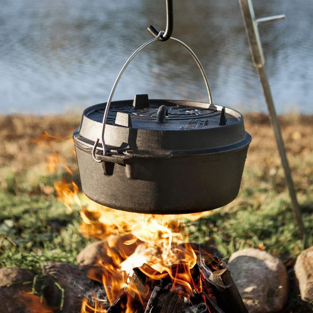 Nahaufnahme eines Dutch ovens an einem Haken über einem Holzfeuer